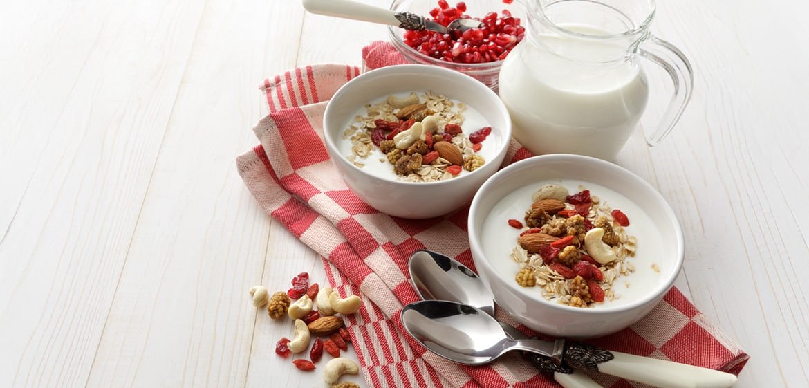 Müsli mit Milch und verschiedenen Nussorten auf einem Tisch.